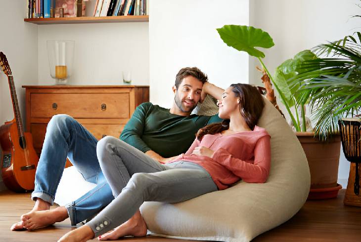 Pareja hablando recostada en sillón